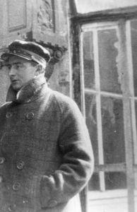 Vertov wearing a peaked cap and checkered coat