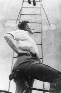 Dziga Vertov auf Fahrrad, von unten fotografiert