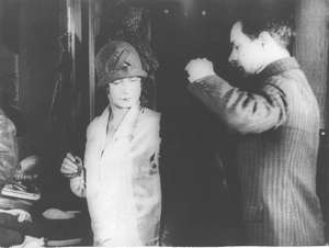 Mann hilft Frau in den Mantel