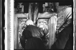 Frau küsst das Kreuz, von hinten